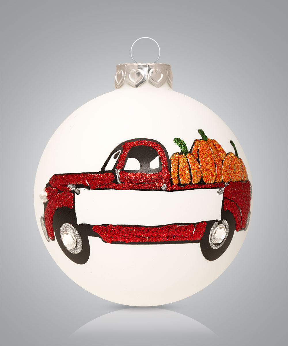Hand-painted glass ornament with a red truck full of pumpkins