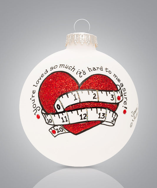 Hand-painted glass ornament with red heart and measuring tape and words “You’re loved so much it’s hard to measure”