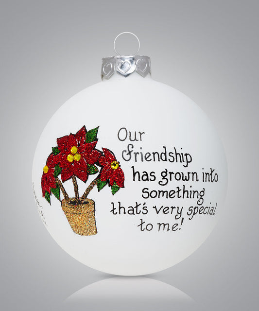 Hand-painted glass ornament with poinsettia and message about friendship growing into something special