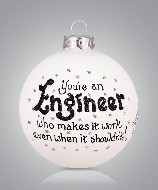 Hand-painted glass ornament with engineer-themed artwork and humorous message about making things work