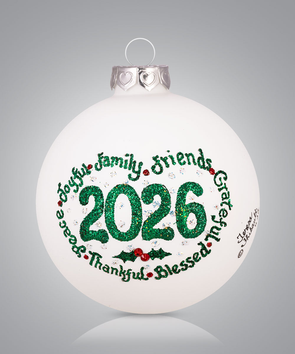 Hand-painted glass ornament featuring 2026 with words like peace, joy, family and friends